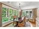 Bright dining room featuring large windows offering serene views of the surrounding greenery and natural light at 4590 Lake Forrest Nw Dr, Atlanta, GA 30342
