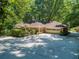 A charming brick home featuring an attached two-car garage and an expansive driveway for ample parking at 4590 Lake Forrest Nw Dr, Atlanta, GA 30342