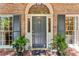 Elegant front entrance boasting a stylish door, decorative sidelights, and manicured potted plants at 4590 Lake Forrest Nw Dr, Atlanta, GA 30342
