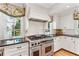 Gourmet kitchen featuring an expansive stainless steel range and custom cabinetry with subway tile backsplash at 4590 Lake Forrest Nw Dr, Atlanta, GA 30342