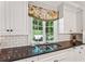 Kitchen sink with double sink, dark countertops and custom floral window treatment overlooking greenery at 4590 Lake Forrest Nw Dr, Atlanta, GA 30342