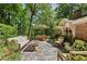 Relaxing outdoor patio with stone flooring, elegant furniture, and an umbrella table set for al fresco dining at 4590 Lake Forrest Nw Dr, Atlanta, GA 30342