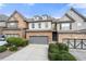Two-story brick and stone townhome with gray garage doors and manicured landscaping at 5649 Cobblestone Creek Pl # 13, Mableton, GA 30126