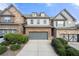 Two-story brick and stone townhome with gray garage doors and manicured landscaping at 5649 Cobblestone Creek Pl # 13, Mableton, GA 30126