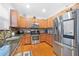 Kitchen featuring wood cabinets, granite countertops, stainless steel appliances, and hardwood floors at 5649 Cobblestone Creek Pl # 13, Mableton, GA 30126