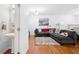 Well-lit living room with hardwood floors, plush sectional sofa, and adjacent powder room at 5649 Cobblestone Creek Pl # 13, Mableton, GA 30126