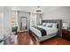 Comfortable bedroom with a queen bed, cherry wood floor, natural light, and a stylish ceiling fan at 840 Ash St, Canton, GA 30114