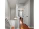 Hallway view of a bedroom with neutral walls, wood floors, and a view of the stairs at 840 Ash St, Canton, GA 30114