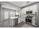 Bright kitchen boasts stainless steel appliances, white cabinets and counters, and adjacent dining area at 840 Ash St, Canton, GA 30114