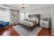 Spacious main bedroom with tray ceiling, fan, wood floors, sitting area, and large window at 840 Ash St, Canton, GA 30114
