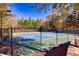 Community tennis court surrounded by trees, with benches and lighting at 840 Ash St, Canton, GA 30114