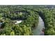 Beautiful aerial shot featuring the community pool surrounded by lush forestry and adjacent to a scenic river at 138 Grand Ave, Suwanee, GA 30024