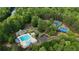 An aerial view of a community's pool and tennis courts, surrounded by lush trees and manicured landscaping at 138 Grand Ave, Suwanee, GA 30024