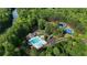 Aerial view of pool, tennis courts, river and clubhouse surrounded by lush green trees at 138 Grand Ave, Suwanee, GA 30024