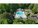 Aerial view of community pool and clubhouse with parking surrounded by mature trees at 138 Grand Ave, Suwanee, GA 30024