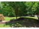 Spacious backyard with lush lawn, wooden fence, and stairs leading up to a deck, perfect for outdoor activities at 138 Grand Ave, Suwanee, GA 30024