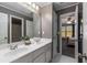 Dual sink vanity with mirror, cabinetry, tub/shower combination and a bedroom entrance at 138 Grand Ave, Suwanee, GA 30024