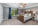 Well-lit bedroom with a queen size bed, a ceiling fan, carpet and a large window view at 138 Grand Ave, Suwanee, GA 30024