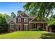 Charming two-story brick home with manicured lawn and mature landscaping on a sunny day at 138 Grand Ave, Suwanee, GA 30024