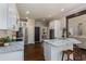 Open kitchen featuring an island with seating, white cabinets, and stainless steel appliances at 138 Grand Ave, Suwanee, GA 30024