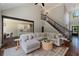 Open-concept living space with a cozy sectional sofa and a view of the dining area and staircase at 138 Grand Ave, Suwanee, GA 30024