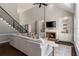 Open living room with high ceilings, fireplace, built-in shelving and staircase at 138 Grand Ave, Suwanee, GA 30024