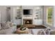 Comfortable living room featuring a stone fireplace, built-in bookshelves, and stylish decor at 138 Grand Ave, Suwanee, GA 30024