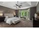 Main bedroom features a tray ceiling, a ceiling fan, and several large windows providing backyard views at 138 Grand Ave, Suwanee, GA 30024