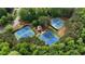 A well-maintained community tennis court complex with lush landscaping and mature shade trees at 138 Grand Ave, Suwanee, GA 30024