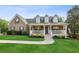 Charming brick home featuring a manicured lawn, welcoming front porch, and dormer windows at 4940 Hanna Kate Ct, Cumming, GA 30028
