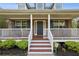 Inviting front porch with classic white railings and a brick facade with brown accents at 4940 Hanna Kate Ct, Cumming, GA 30028