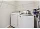 Functional laundry room features a washer, dryer, and storage shelves, enhancing convenience at 4940 Hanna Kate Ct, Cumming, GA 30028
