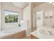 Bright bathroom with a garden tub, double vanity, and a sunlit window at 4940 Hanna Kate Ct, Cumming, GA 30028