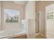 Bathroom with a soaking tub, glass enclosed shower and backyard view at 4940 Hanna Kate Ct, Cumming, GA 30028