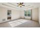 Large primary bedroom boasts a tray ceiling, plush carpet, and backyard view at 4940 Hanna Kate Ct, Cumming, GA 30028