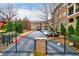 Gated community entrance featuring brick buildings, mature landscaping, and convenient parking at 625 Piedmont Ne Ave # 2004, Atlanta, GA 30308