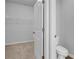 Bathroom featuring open door to walk-in closet and view of white toilet at 6920 Oak Valley Dr, Douglasville, GA 30134
