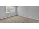 Bright bedroom with neutral carpet and paint, and a large window for natural light at 6920 Oak Valley Dr, Douglasville, GA 30134