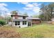 Spacious backyard with a manicured lawn, the house's rear exterior, with a sunroom and brick features at 753 Brookwood Sw Ter, Lilburn, GA 30047