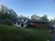 View of backyard featuring a well-maintained lawn, brick house and attached sunroom at 753 Brookwood Sw Ter, Lilburn, GA 30047