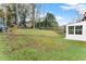Spacious backyard with lush green lawn, mature trees, and a section of white siding of the home visible at 753 Brookwood Sw Ter, Lilburn, GA 30047