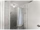 Shower in a bathroom featuring white marble-look tile and a shower curtain at 753 Brookwood Sw Ter, Lilburn, GA 30047