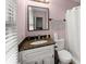 Bathroom with granite counters, large vanity, and framed mirror at 753 Brookwood Sw Ter, Lilburn, GA 30047
