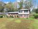 Charming split-level home featuring a well-maintained lawn and classic brick and siding design at 753 Brookwood Sw Ter, Lilburn, GA 30047