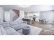 Open-concept living area with a cozy sectional, modern kitchen, dining area, and staircase at 2797 Malton Way, Loganville, GA 30052