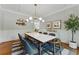 Bright dining room with white wainscoting, modern light fixture, and stylish seating for six at 3990 Old Spring House Ct, Atlanta, GA 30338
