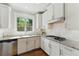 Well-lit kitchen featuring white cabinets, granite countertops, stainless steel appliances, and a gas range stove at 3990 Old Spring House Ct, Atlanta, GA 30338