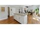 Spacious kitchen island with white cabinets, granite countertop and bar stool seating that opens up to the living room at 3990 Old Spring House Ct, Atlanta, GA 30338