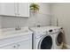 Laundry room with washer, dryer, sink, and upper cabinets at 3990 Old Spring House Ct, Atlanta, GA 30338