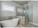 Modern bathroom features a freestanding tub and glass-enclosed shower with decorative tiling at 4425 Atwood Dr, Cumming, GA 30040